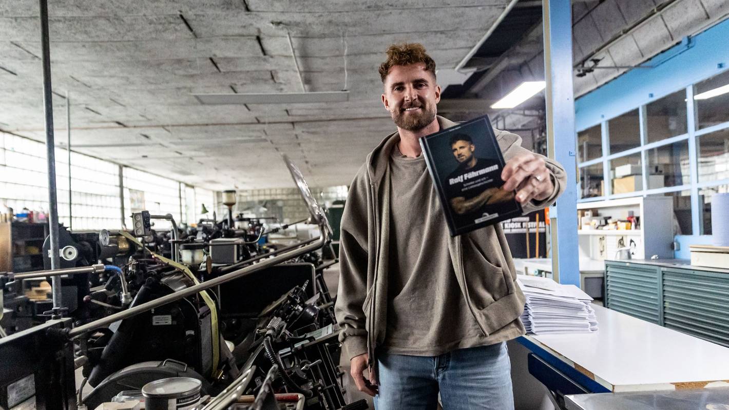 Der ehemalige Schalke-Torwart Ralf Fährmann hält sein Buch in der Hand.