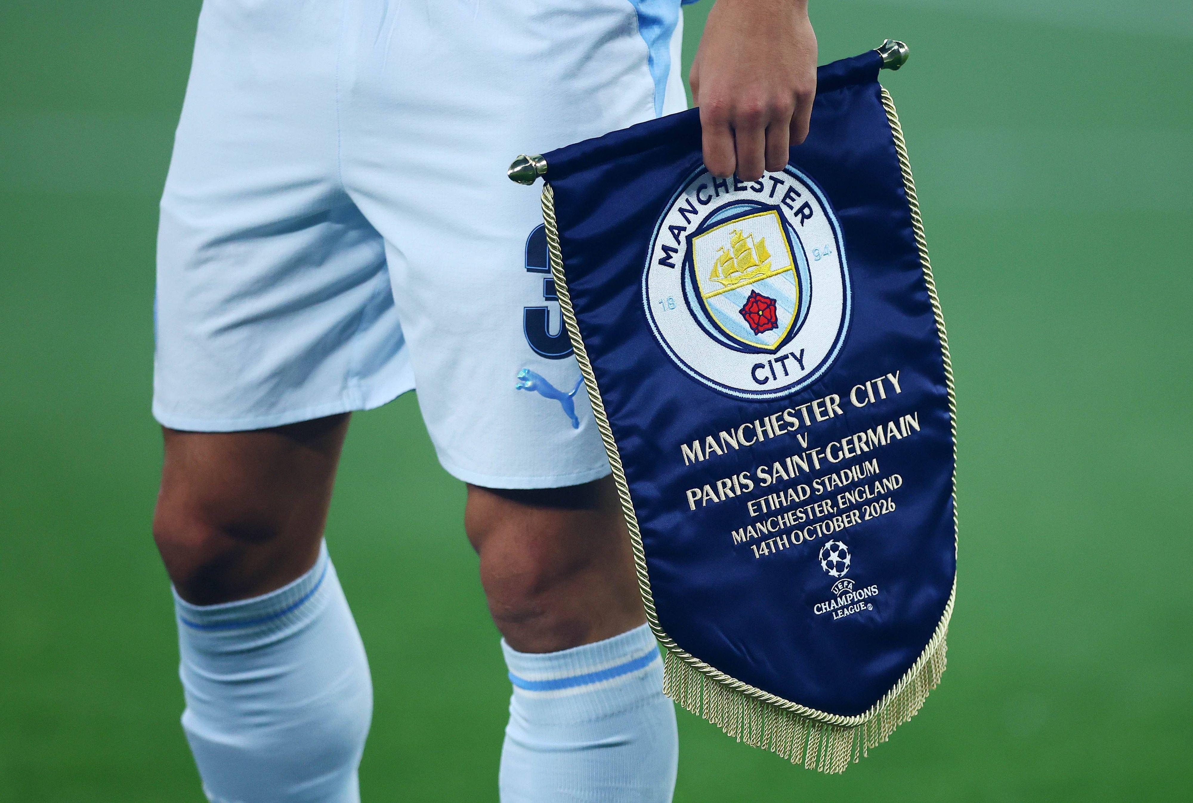 Ein Profi von Manchester City trägt das Vereinslogo auf einem Wimpel.