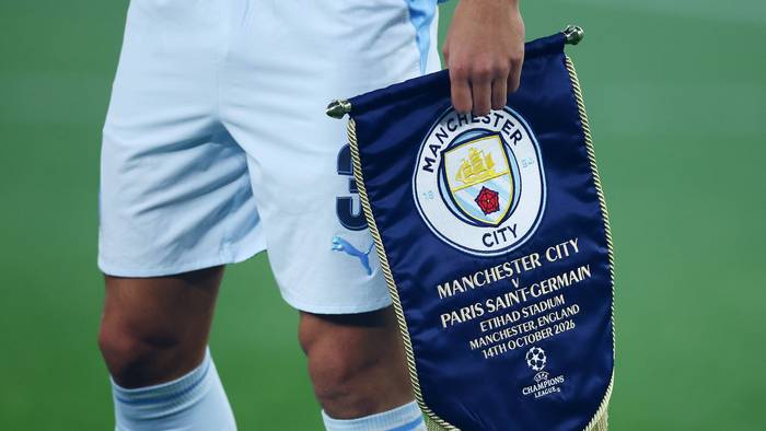 Ein Profi von Manchester City trägt das Vereinslogo auf einem Wimpel.
