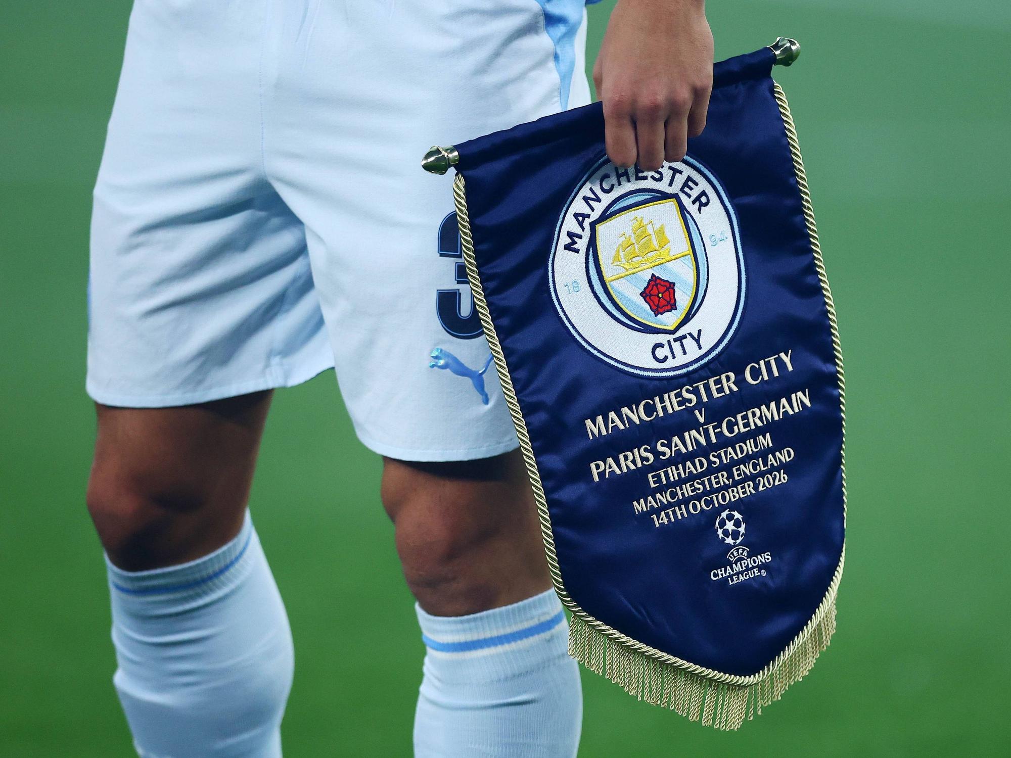 Ein Profi von Manchester City trägt das Vereinslogo auf einem Wimpel.