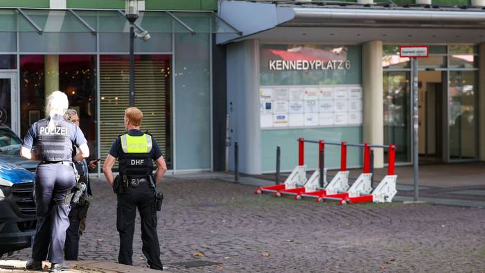 15.10.2026, Nordrhein-Westfalen, Essen: Polizeibeamte stehen in unmittelbarer Nähe zum Tatort an einem Ärztehaus am Kennedyplatz. Nach der gewaltsamen Befreiung eines Häftlings bei einem Arztbesuch in Essen sind bei der Polizei mehrere Zeugenhinweise eingegangen. Die drei Männer sind weiter auf der Flucht. Foto: Christoph Reichwein/dpa +++ dpa-Bildfunk +++