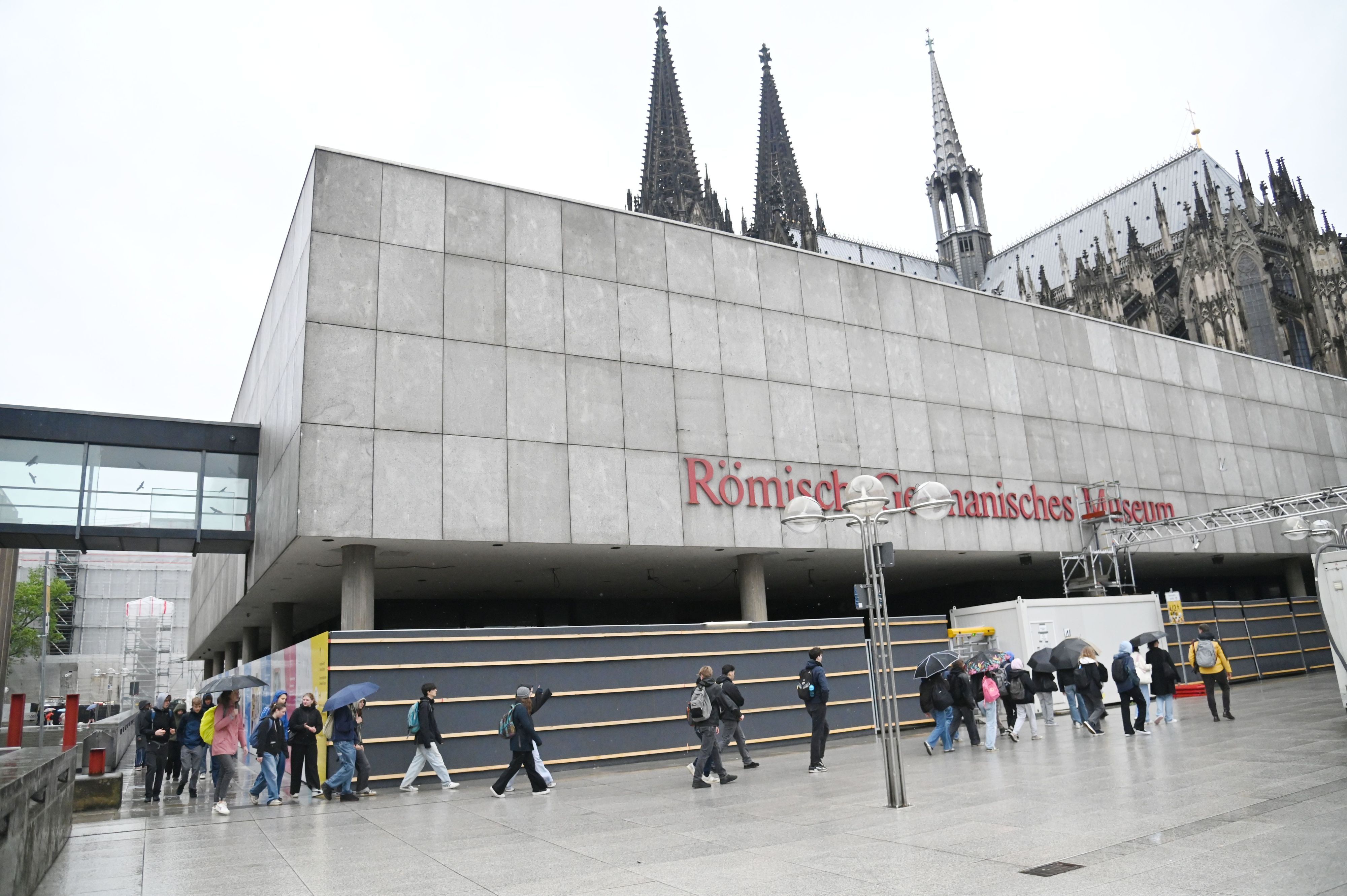 Menschen gehen am Römisch Germanischen Museum vorbei.