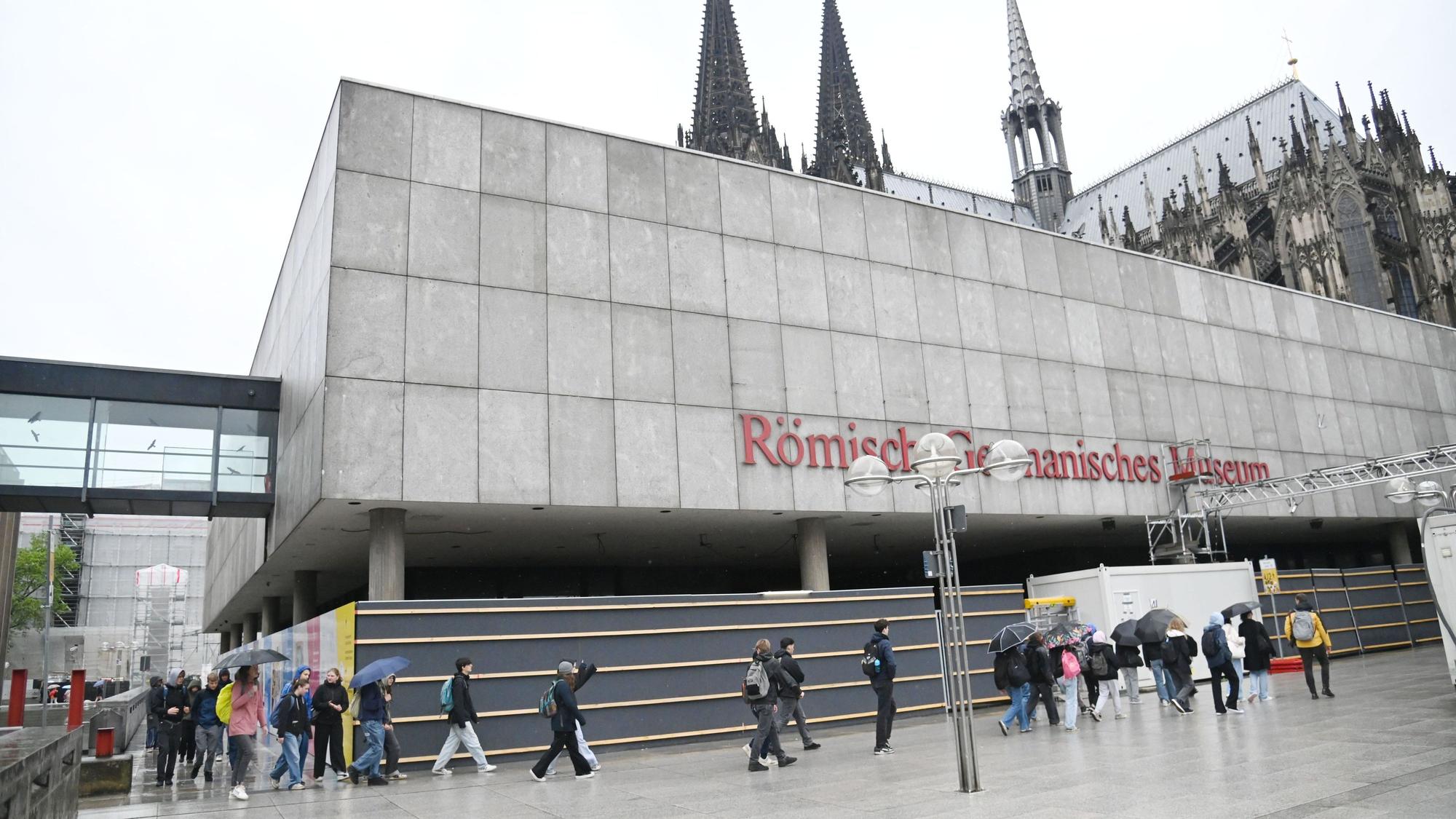 Menschen gehen am Römisch Germanischen Museum vorbei.