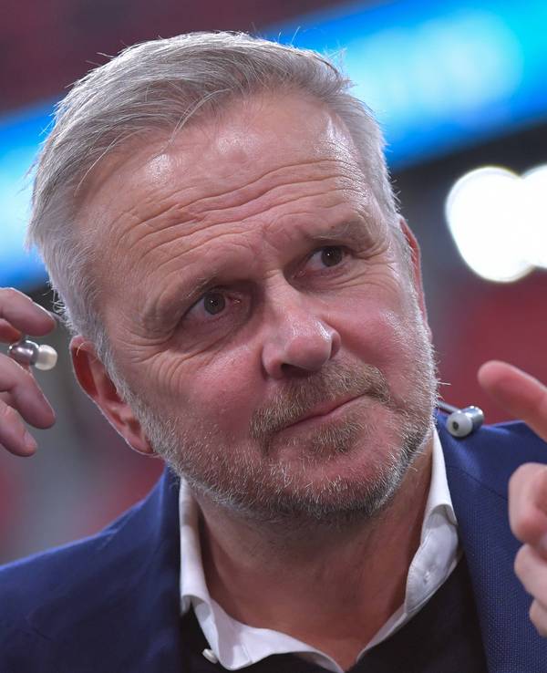 Dietmar Hamann steckt sich einen Kopfhörer ins Ohr.