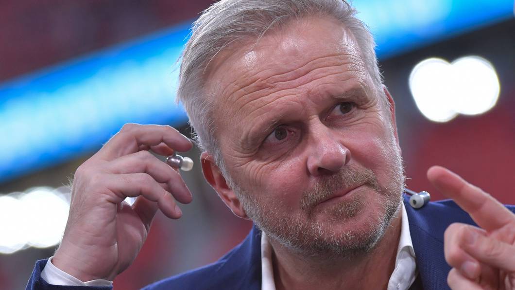 Dietmar Hamann steckt sich einen Kopfhörer ins Ohr.