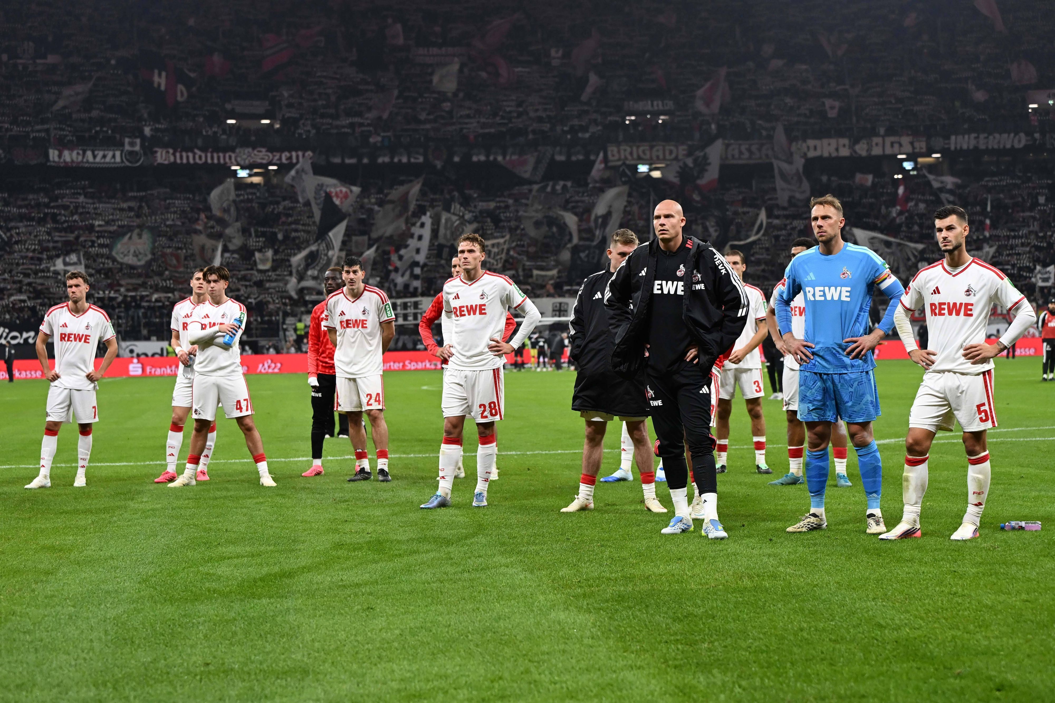 Die Spieler des 1. FC Köln stehen nach der Niederlage in Frankfurt enttäuscht auf dem Rasen vor den mitgereisten Fans.