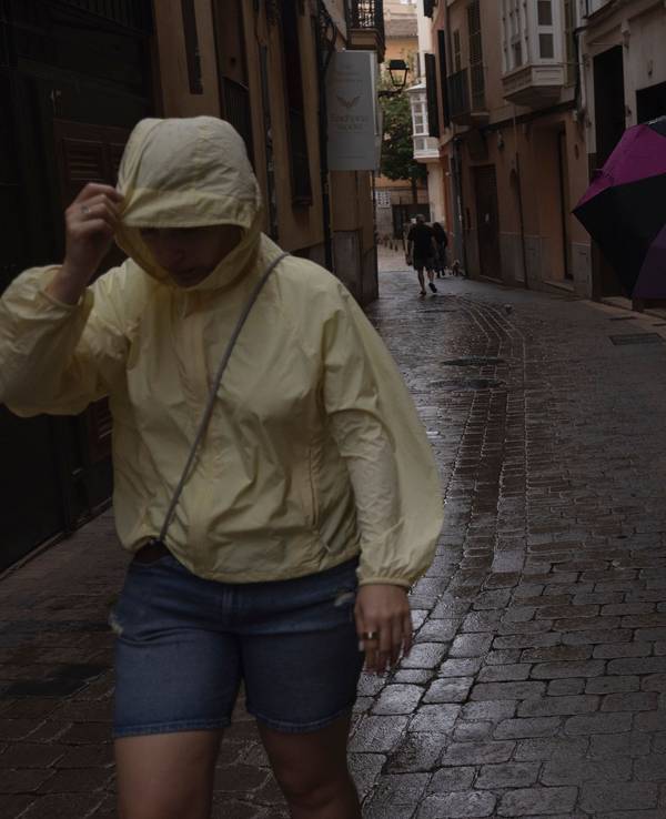 Menschen gehen im Regen durch die Innenstadt von Palma. Der Sturm „Adam“ zieht über die Insel hinweg, und für die Bevölkerung wurde eine rote Warnstufe ausgerufen.