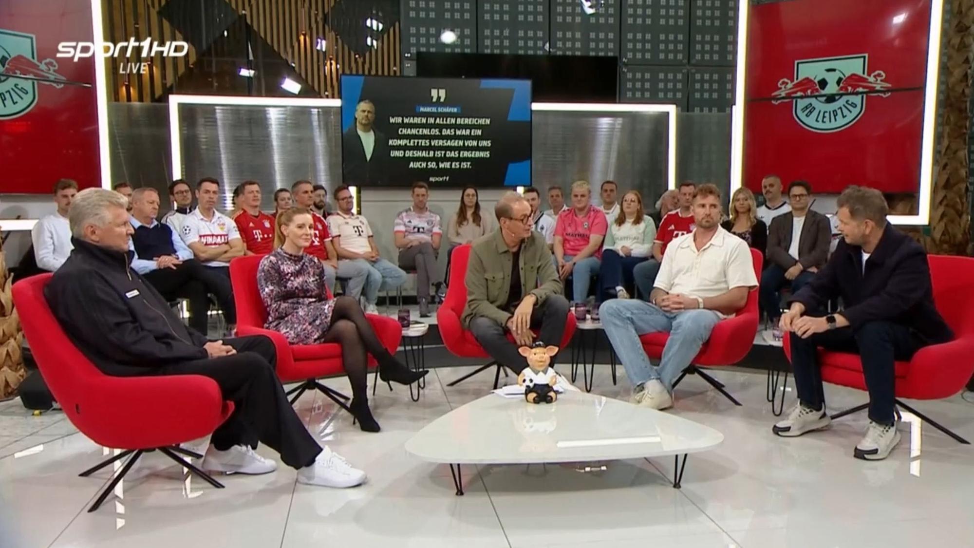 Die Doppelpass-Gäste und Moderator Florian König sitzen auf roten Sesseln.