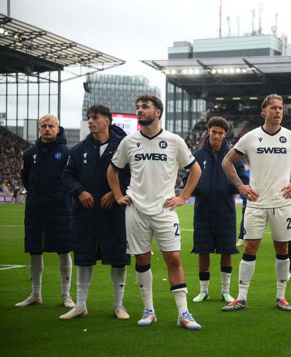 Die Spieler aus Karlsruhe stehen nach einer Niederlage vor ihren Fans auf der Gästetribüne.