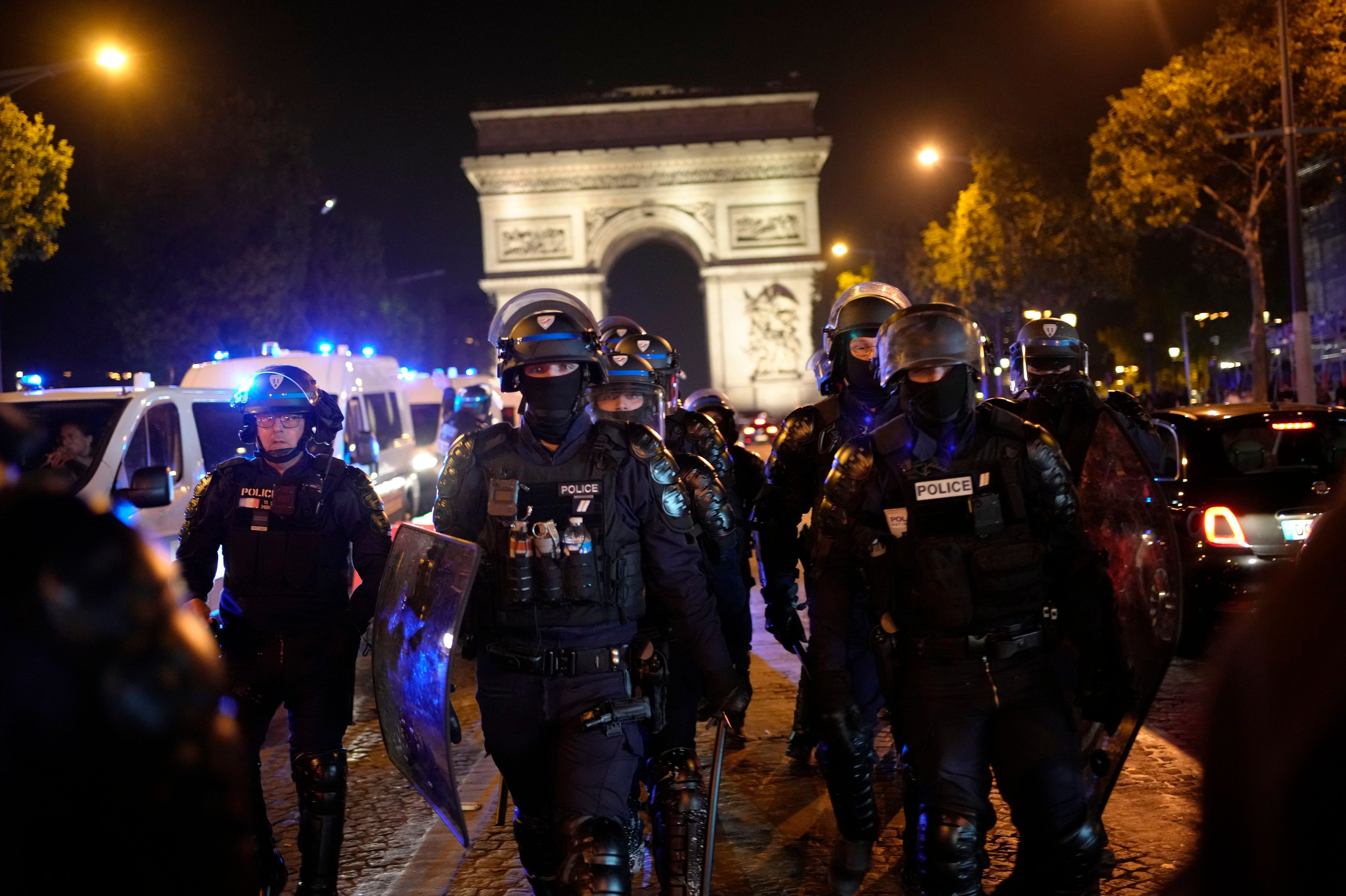 Polizisten patrouillieren vor dem Arc de Triomphe auf der Champs Elysees.