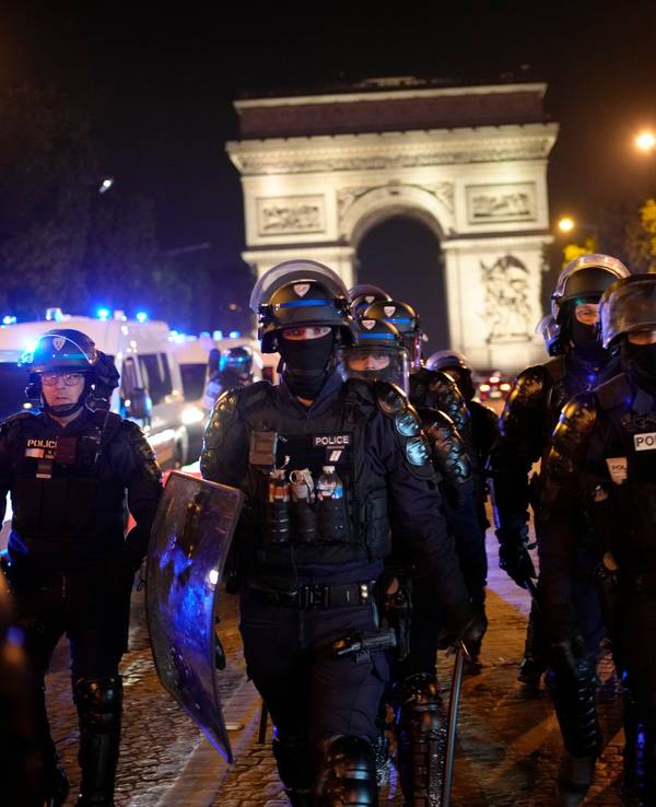 Polizisten patrouillieren vor dem Arc de Triomphe auf der Champs Elysees.