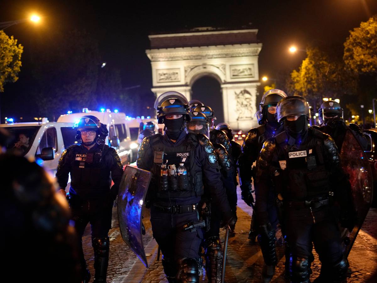 Polizisten patrouillieren vor dem Arc de Triomphe auf der Champs Elysees.