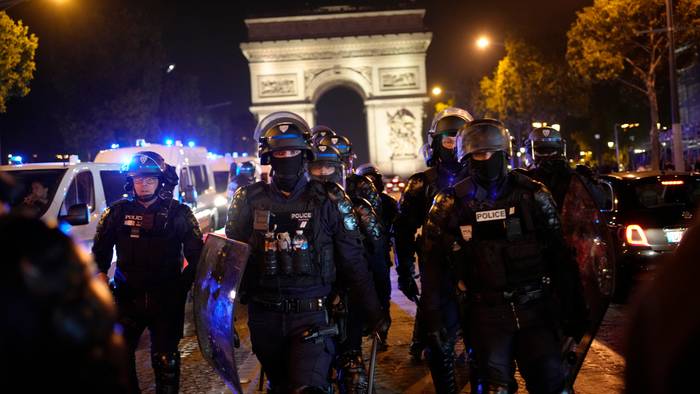 Polizisten patrouillieren vor dem Arc de Triomphe auf der Champs Elysees.