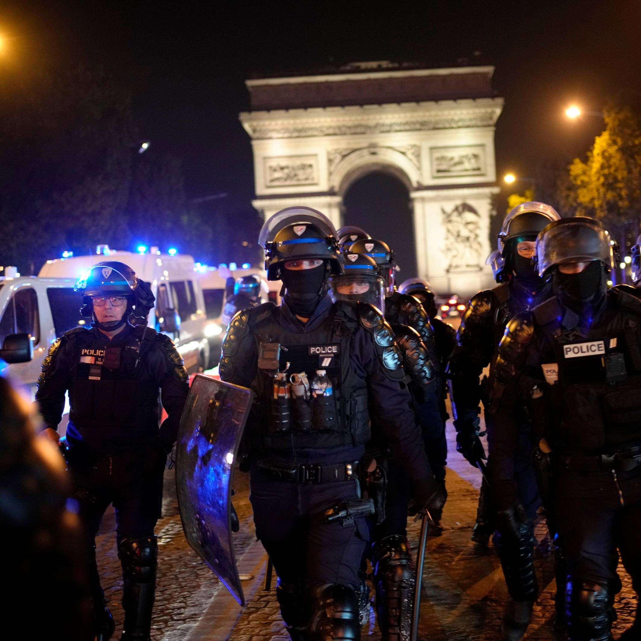 Polizisten patrouillieren vor dem Arc de Triomphe auf der Champs Elysees.
