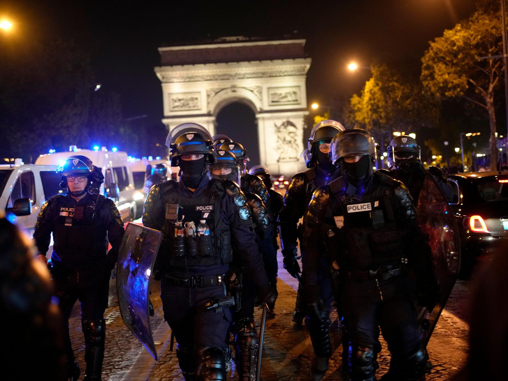 Polizisten patrouillieren vor dem Arc de Triomphe auf der Champs Elysees.