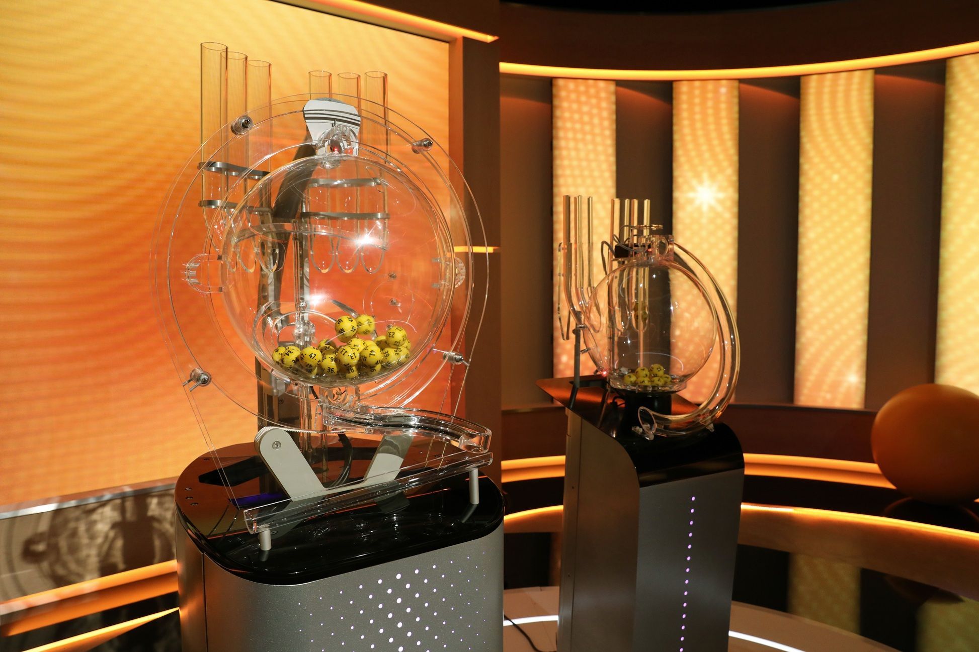 Ziehungsmaschine mit gelben Lotteriekugeln im Eurojackpot-Fernsehstudio.