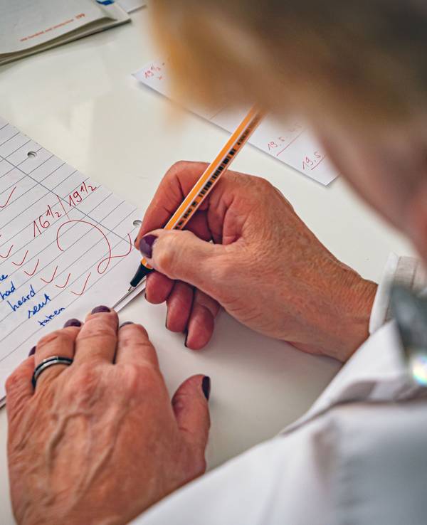 Eine Lehrerin korrigiert Klassenarbeiten. (Symbolfoto)