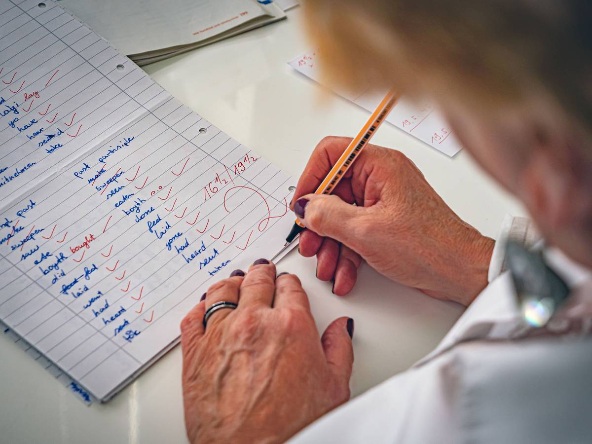 Eine Lehrerin korrigiert Klassenarbeiten. (Symbolfoto)