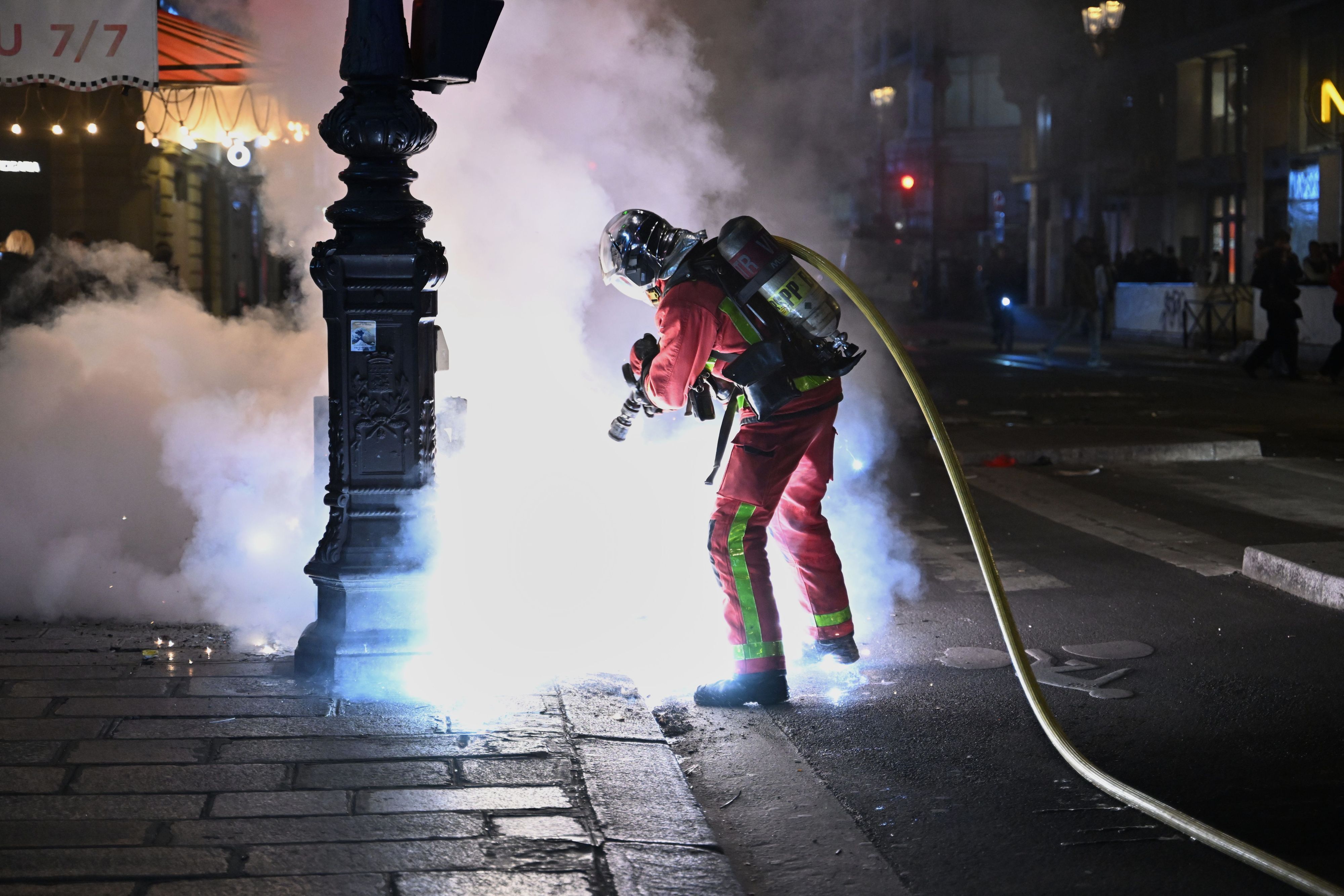 Ein Feuerwehrmann löscht einen Brand während Zusammenstößen zwischen Demonstranten und der Polizei.