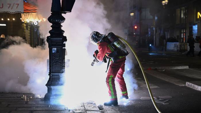 Ein Feuerwehrmann löscht einen Brand während Zusammenstößen zwischen Demonstranten und der Polizei.