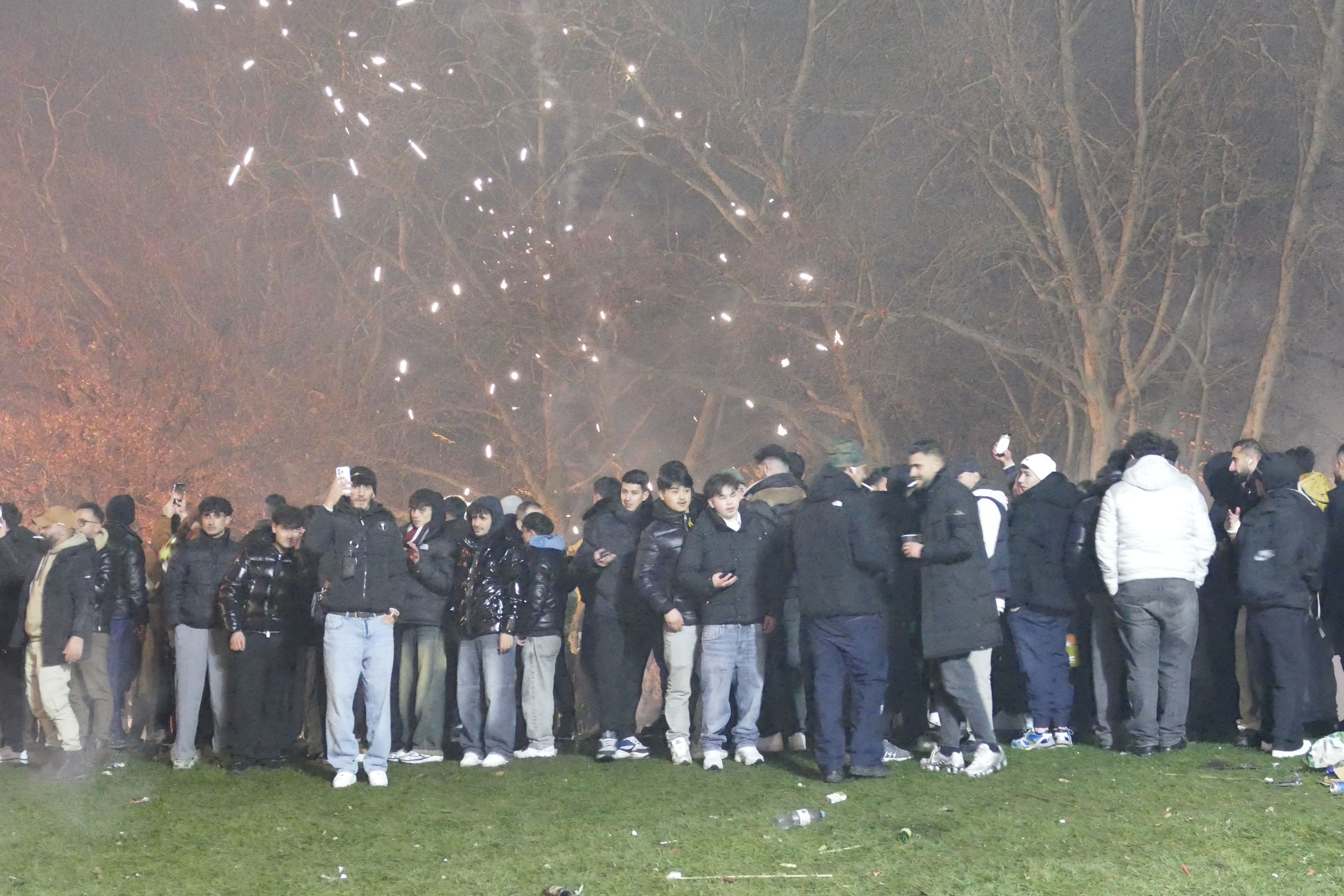 Menschen stehen in der Silvesternacht 2025 am überfüllten linken Rheinufer.