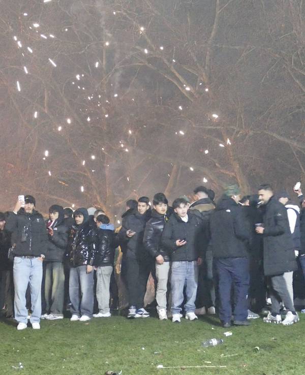 Menschen stehen in der Silvesternacht 2025 am überfüllten linken Rheinufer.