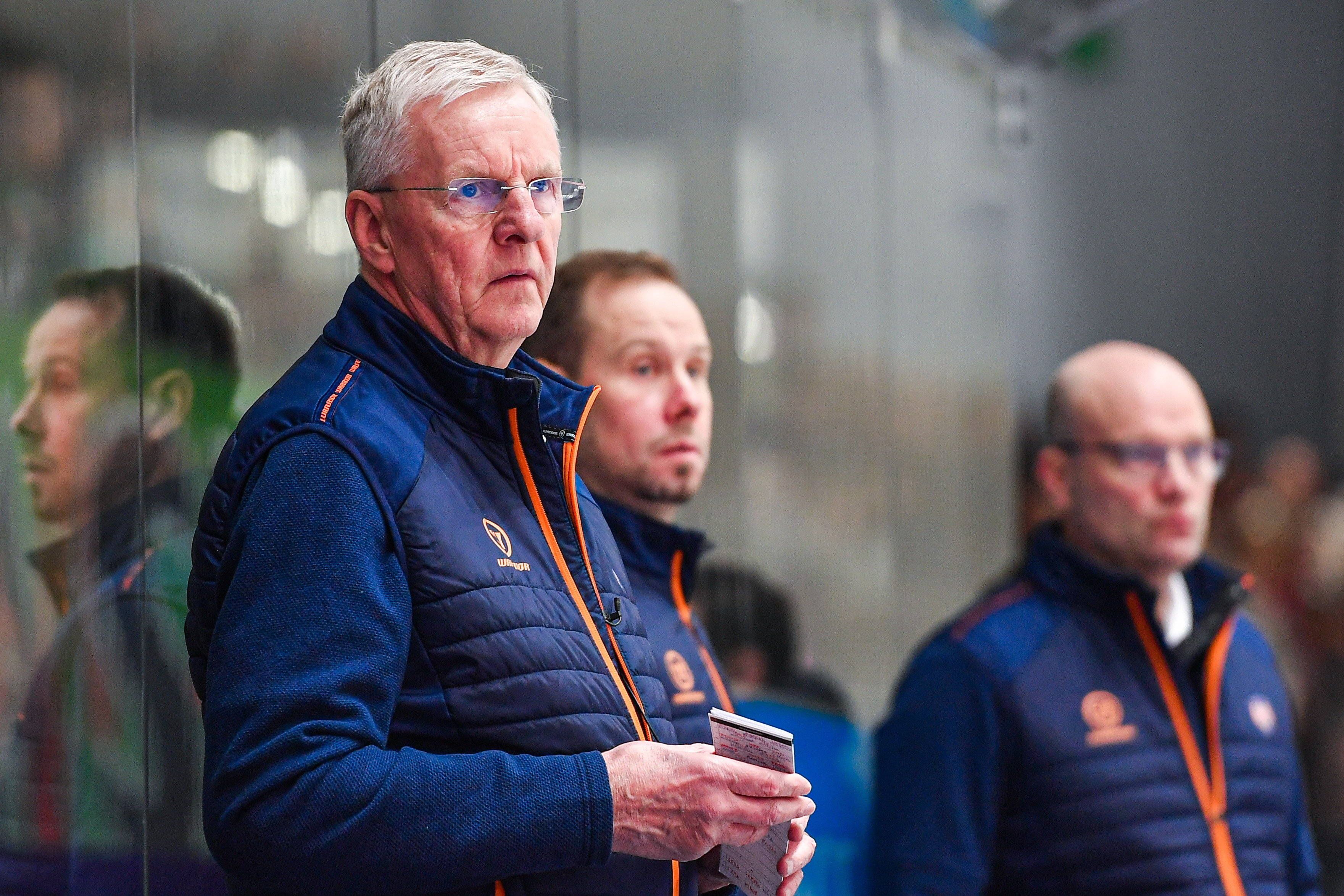 Kari Jalonen steht mit seinem Trainerteam auf der Trainerbank.