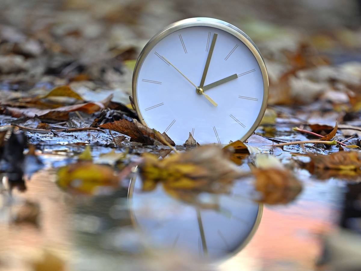 Eine Uhr spiegelt sich im blätterbedeckten Wasser. Mit Beginn der Winterzeit werden in Deutschland und den meisten anderen Ländern Europas am Sonntagmorgen (25. Oktober) die Uhren von 3.00 Uhr auf 2.00 Uhr zurückgestellt.