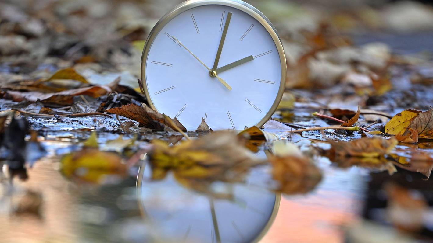 Eine Uhr spiegelt sich im blätterbedeckten Wasser. Mit Beginn der Winterzeit werden in Deutschland und den meisten anderen Ländern Europas am Sonntagmorgen (25. Oktober) die Uhren von 3.00 Uhr auf 2.00 Uhr zurückgestellt.