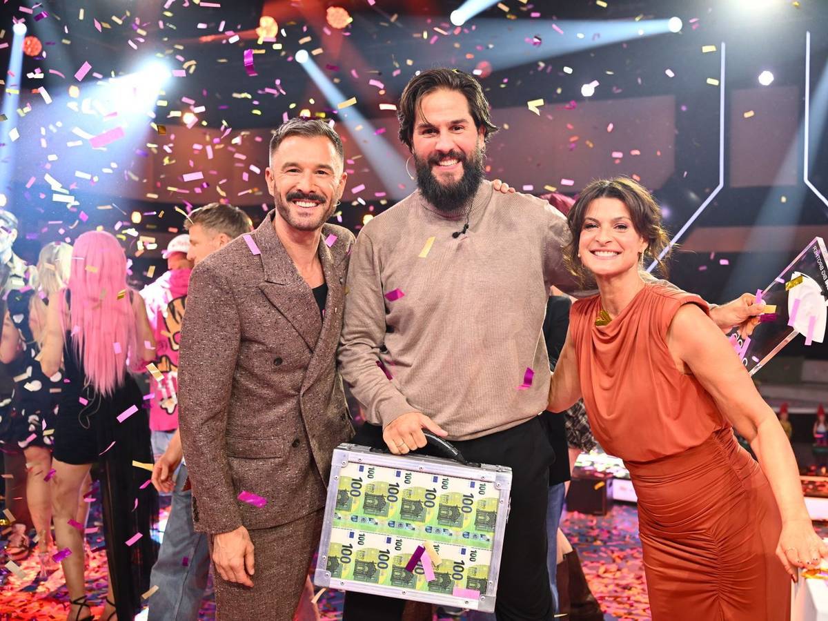 Maurice Dziwak (Mitte) bekommt von Jochen Schropp und Marlene Lufen den Pokal und 100.000 Euro überreicht. (Bild: Joyn/Willi Weber)