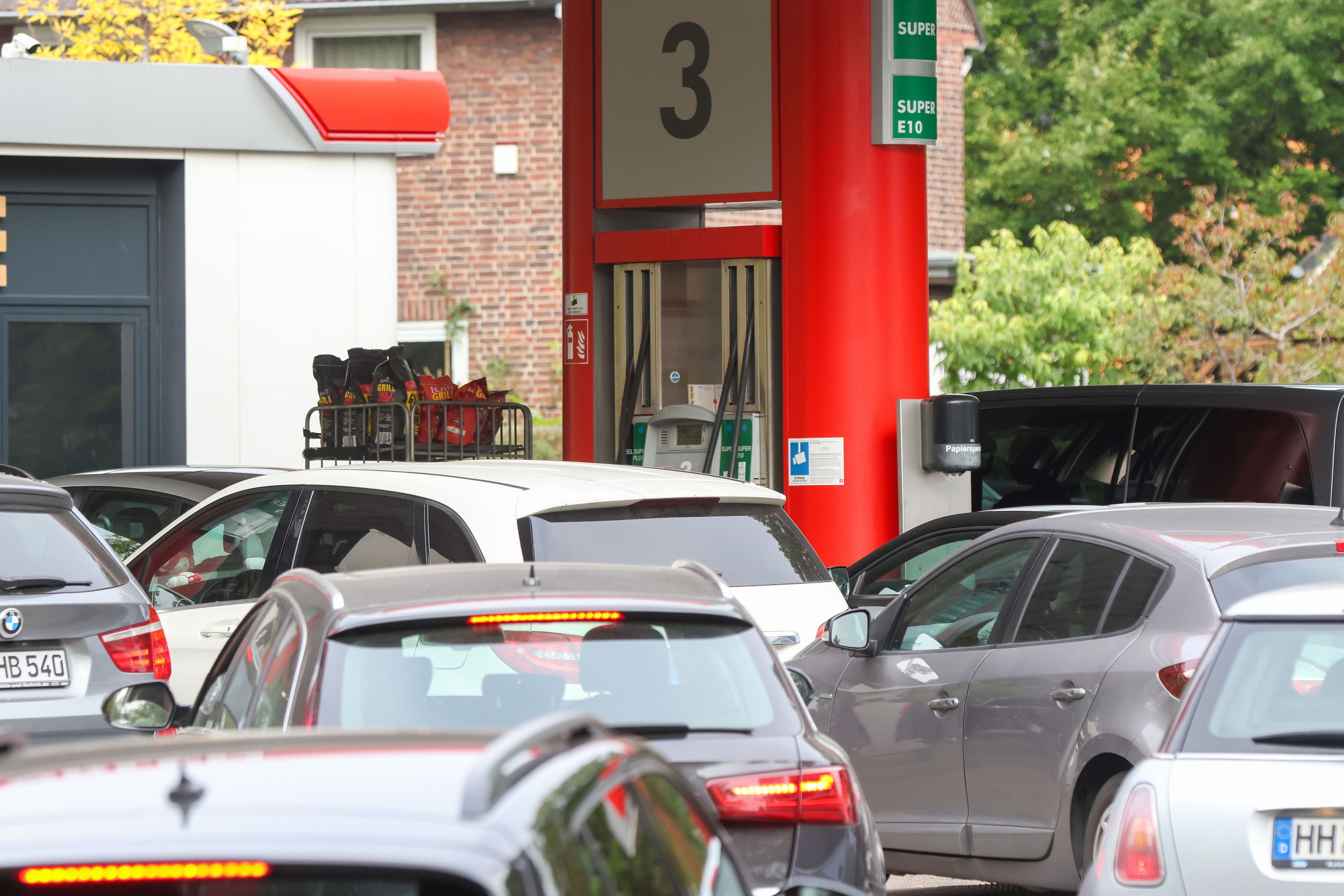 Autos stehen an einer Tankstelle Schlange.