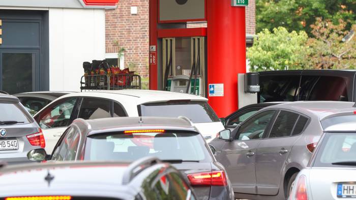 Autos stehen an einer Tankstelle Schlange.