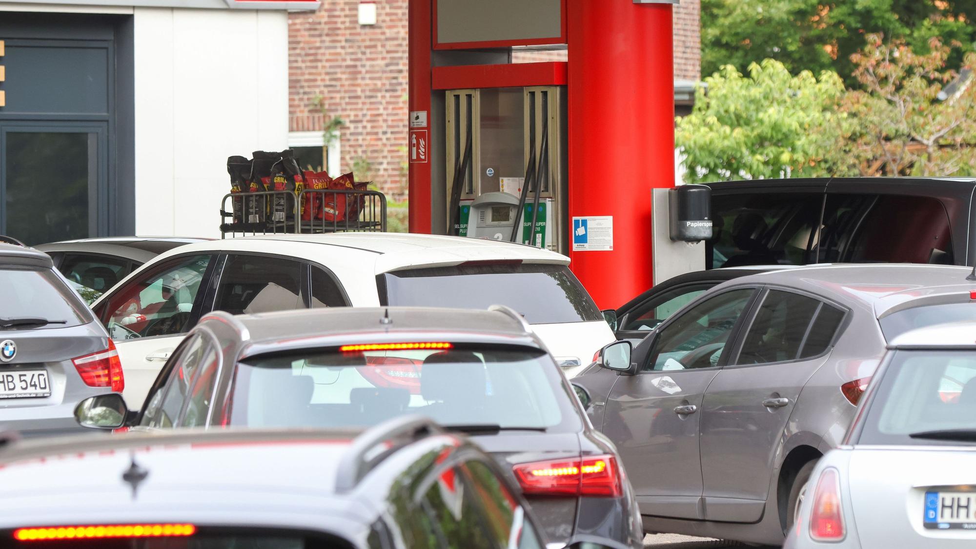 Autos stehen an einer Tankstelle Schlange.
