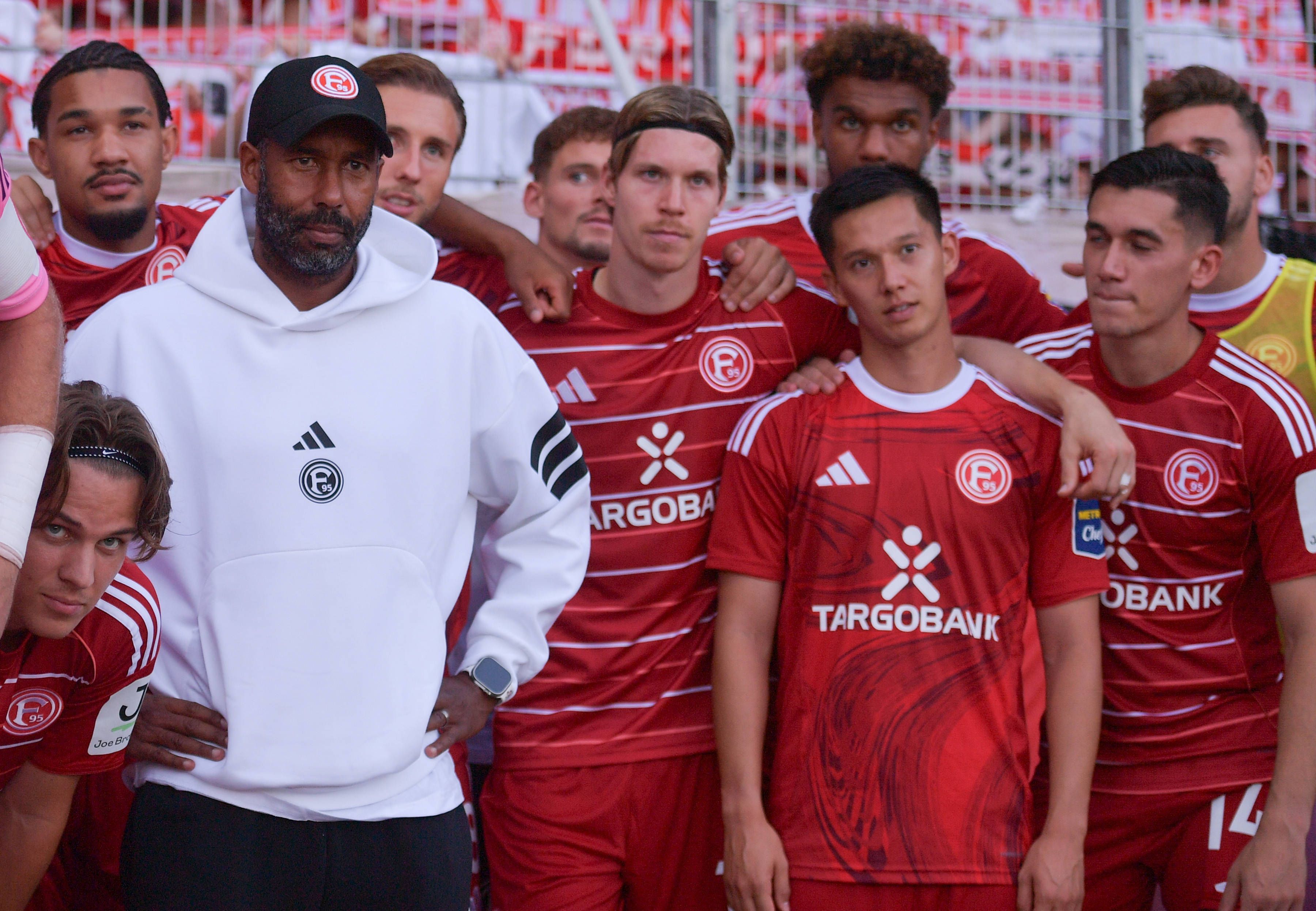Die Mannschaft von Fortuna Düsseldorf steht beisammen und schaut an der Kamera vorbei.