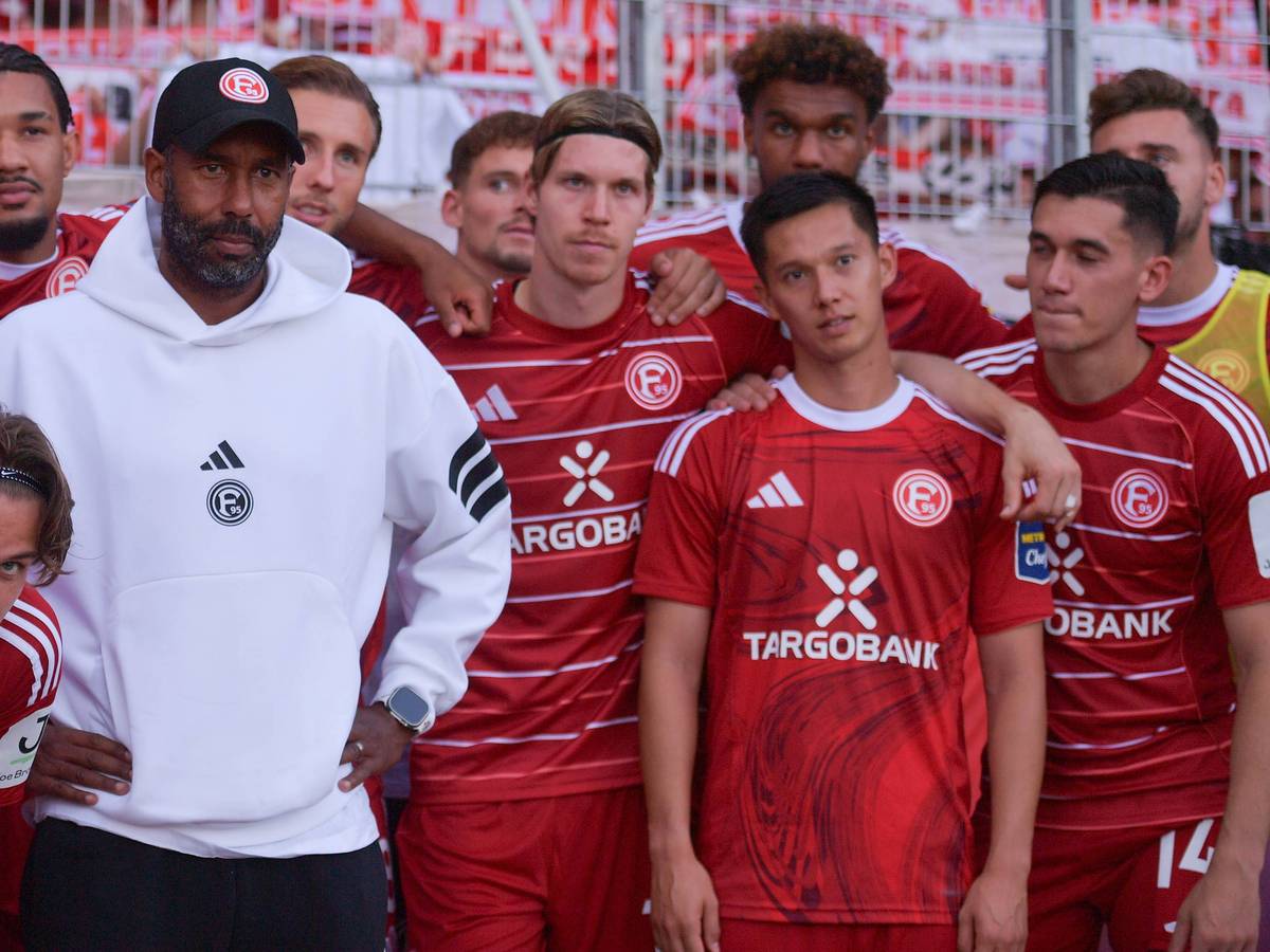 Die Mannschaft von Fortuna Düsseldorf steht beisammen und schaut an der Kamera vorbei.