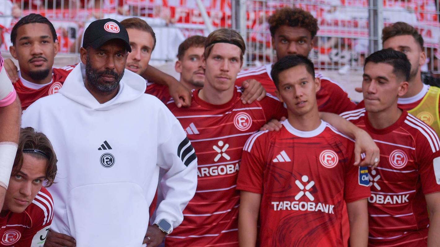 Die Mannschaft von Fortuna Düsseldorf steht beisammen und schaut an der Kamera vorbei.