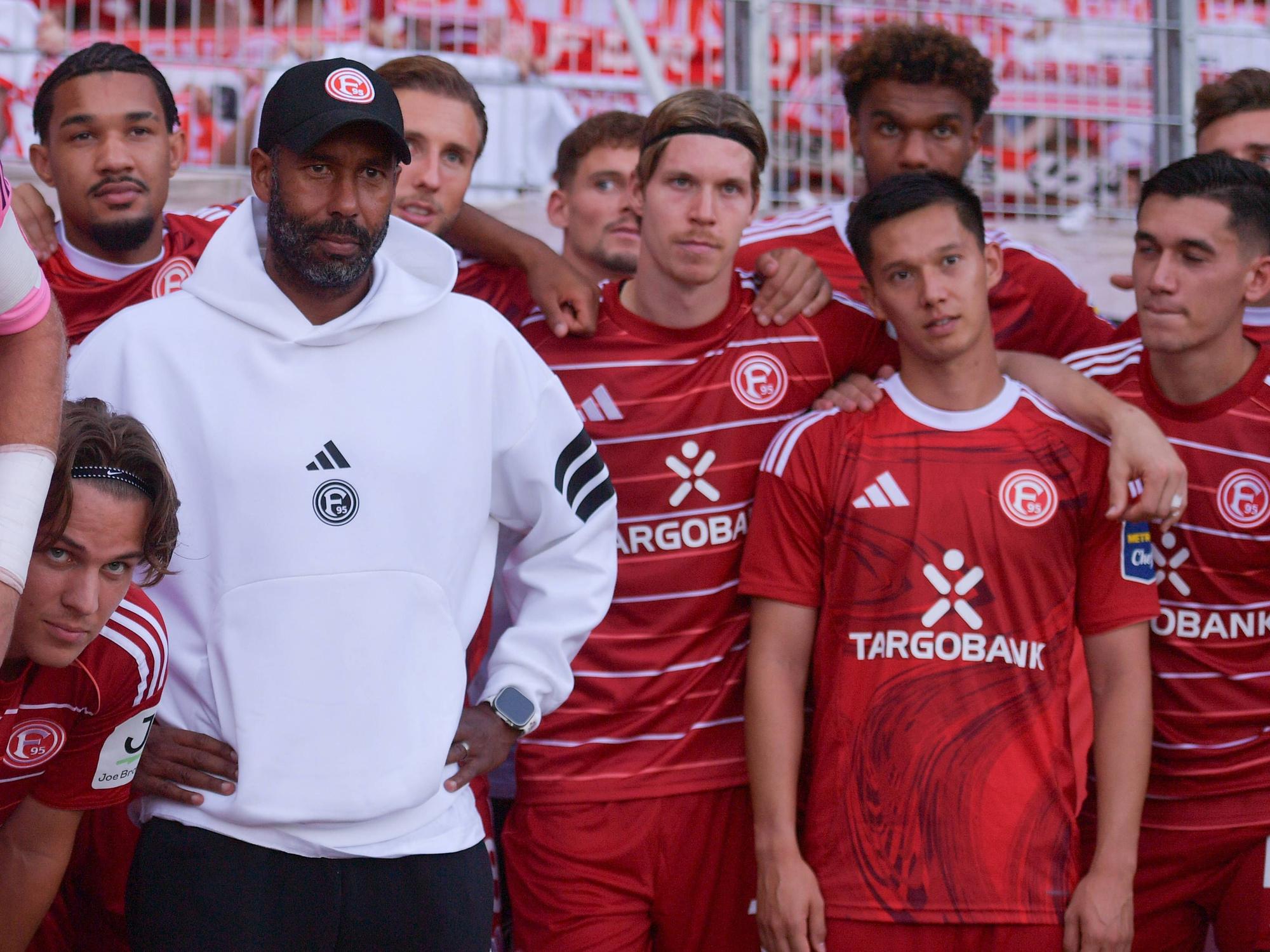Die Mannschaft von Fortuna Düsseldorf steht beisammen und schaut an der Kamera vorbei.