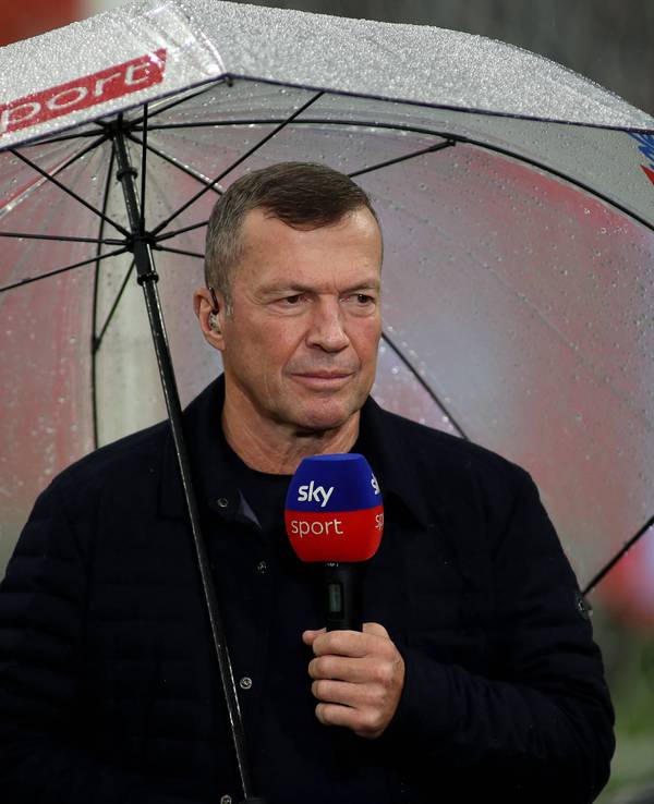 Lothar Matthäus mit Regenschirm und Sky-Mikro im Stadion.