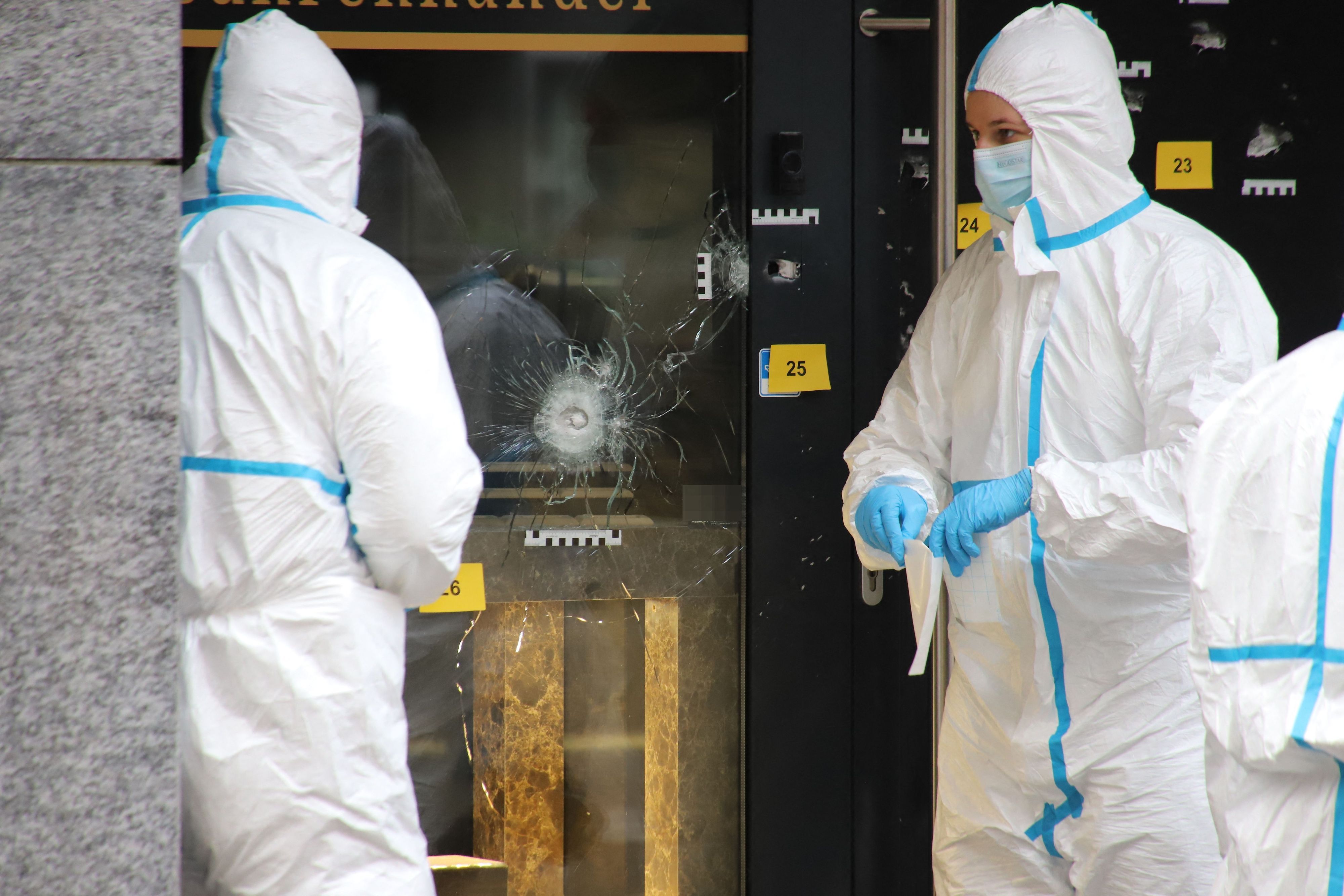 Zwei Einsatzkräfte in Schutzanzügen arbeiten am Einsatzort.