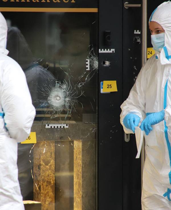 Zwei Einsatzkräfte in Schutzanzügen arbeiten am Einsatzort.