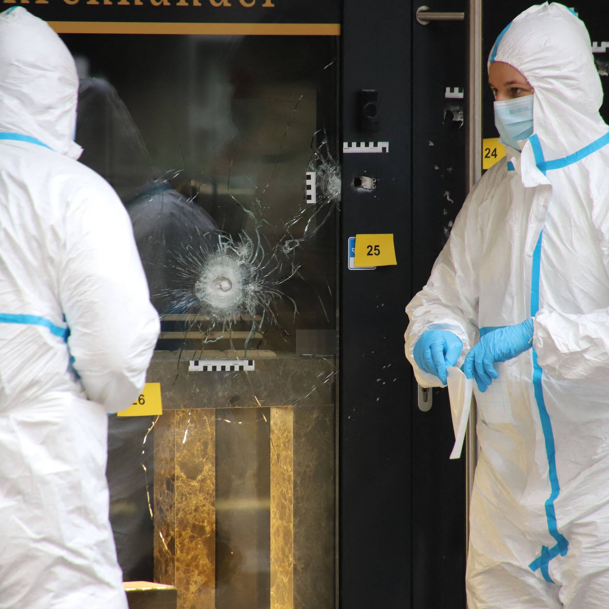 Zwei Einsatzkräfte in Schutzanzügen arbeiten am Einsatzort.