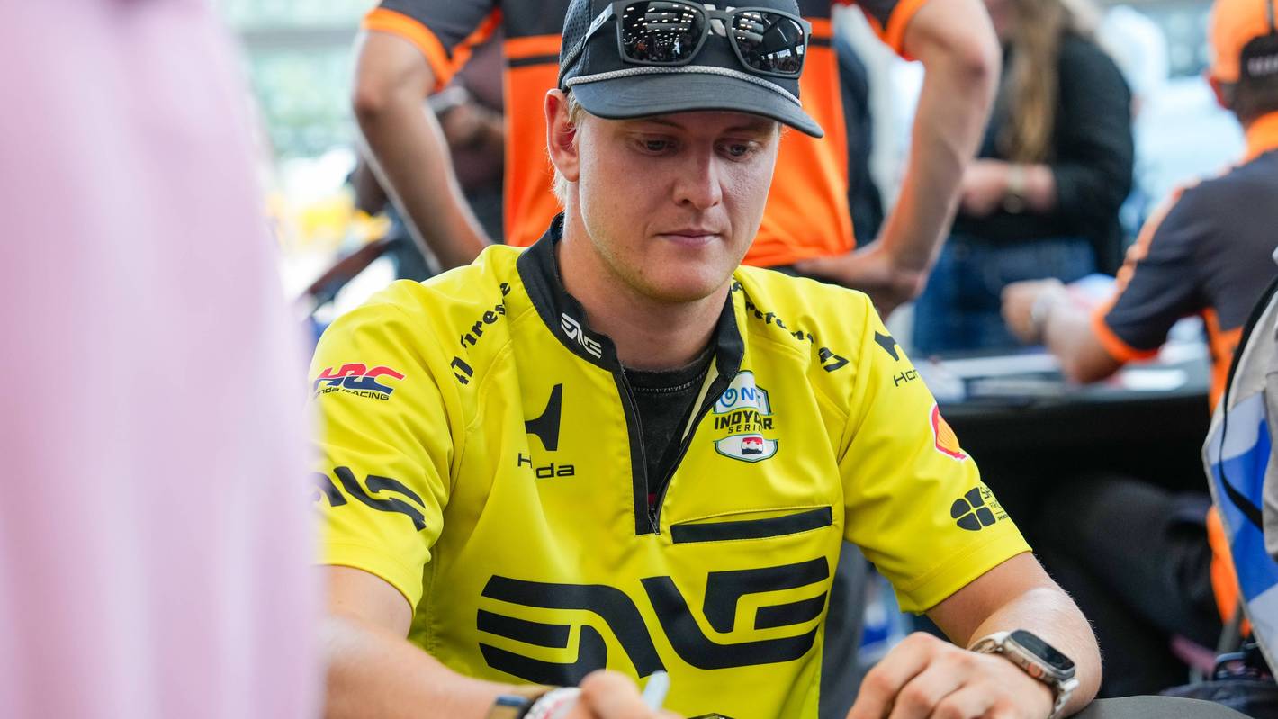 Mick Schumacher schreibt Autogrammt.