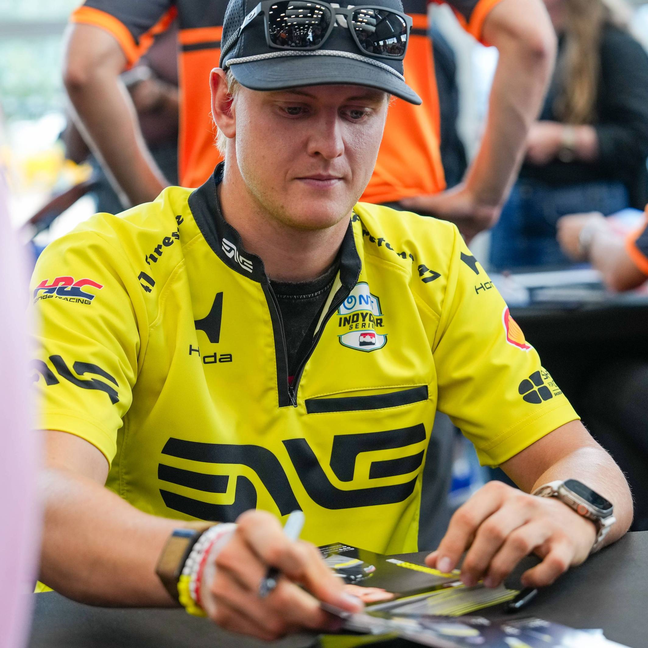 Mick Schumacher schreibt Autogrammt.