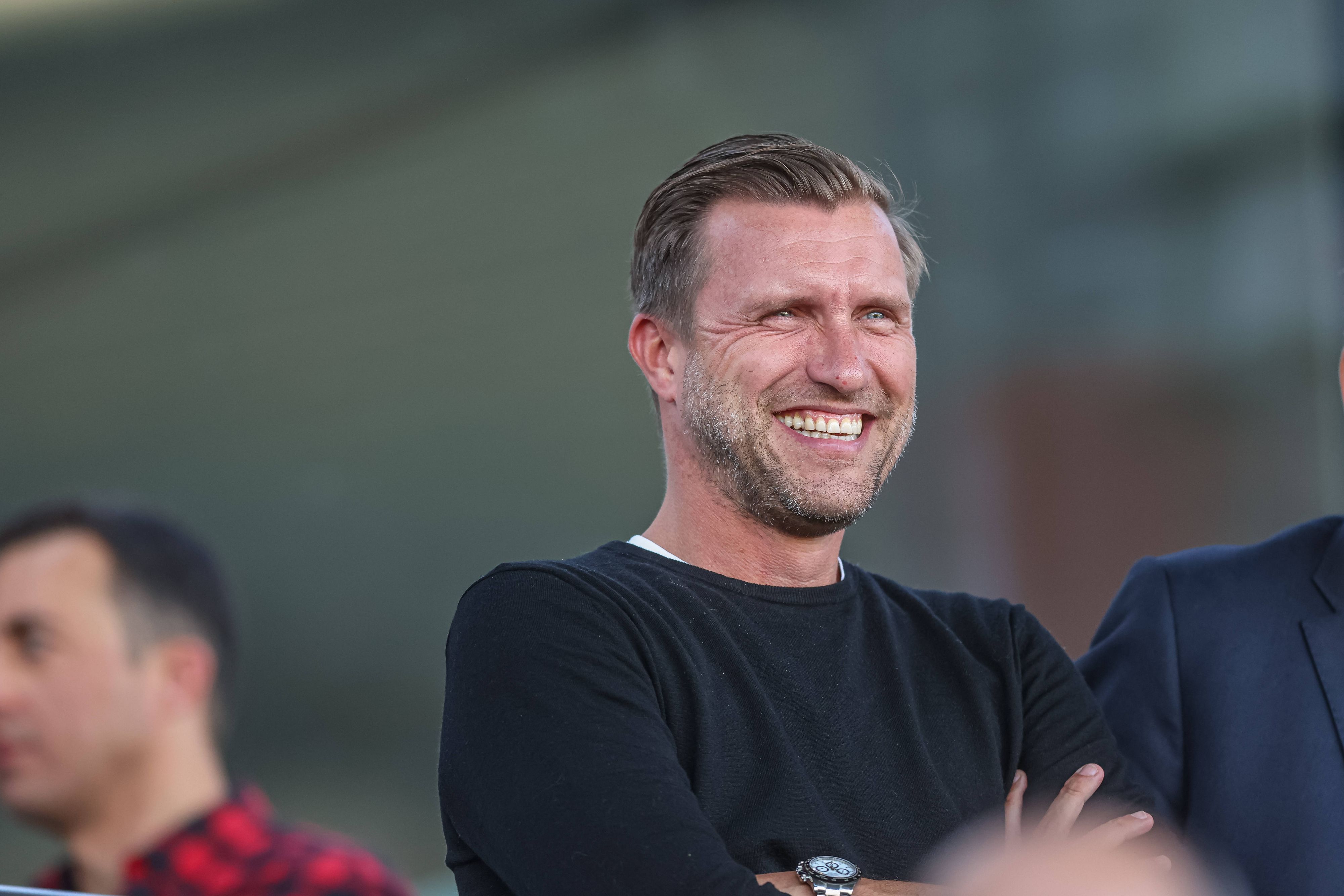 Markus Krösche lacht beim Spiel Eintracht Frankfurt gegen den FC Bayern München in der Frauen-Bundesliga.