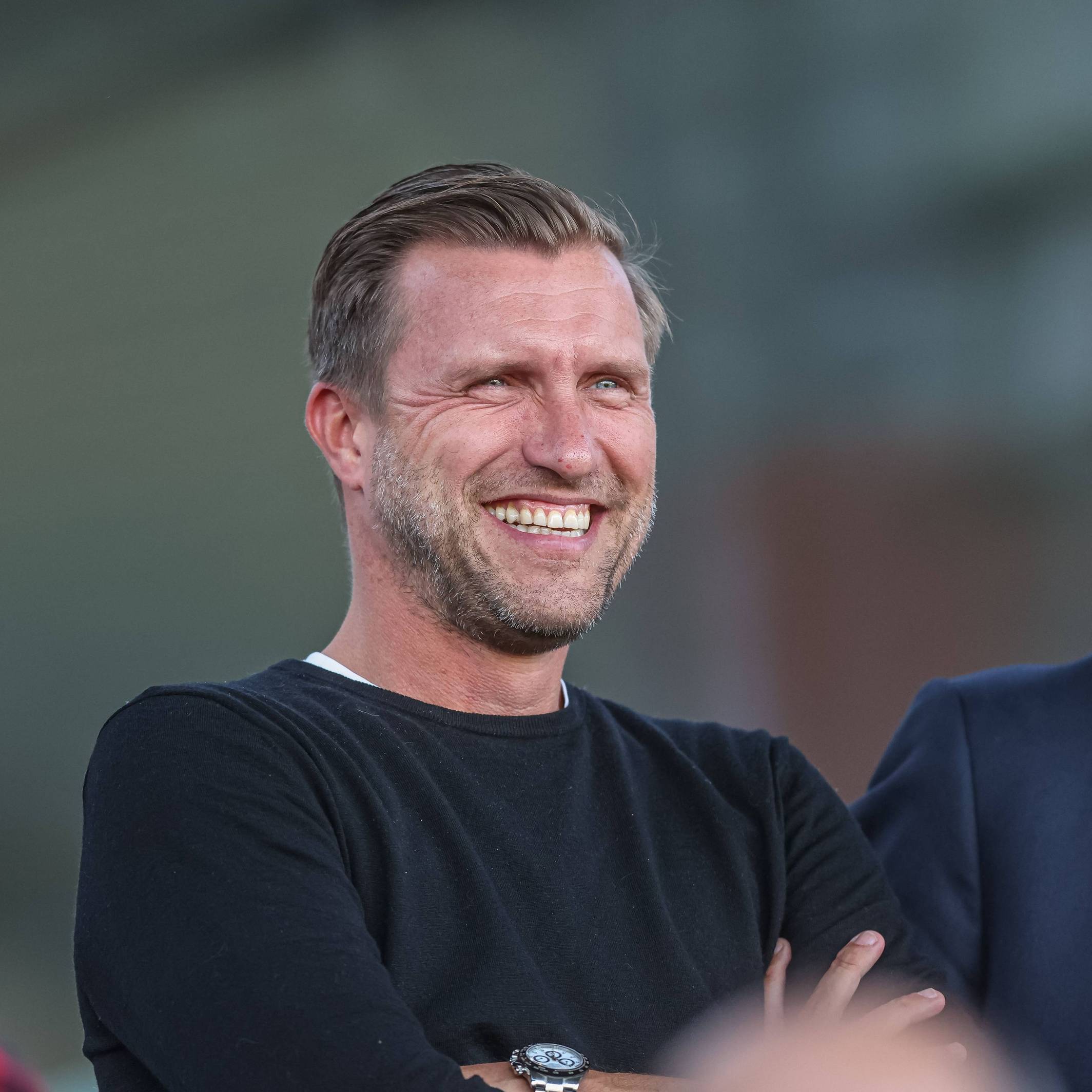 Markus Krösche lacht beim Spiel Eintracht Frankfurt gegen den FC Bayern München in der Frauen-Bundesliga.