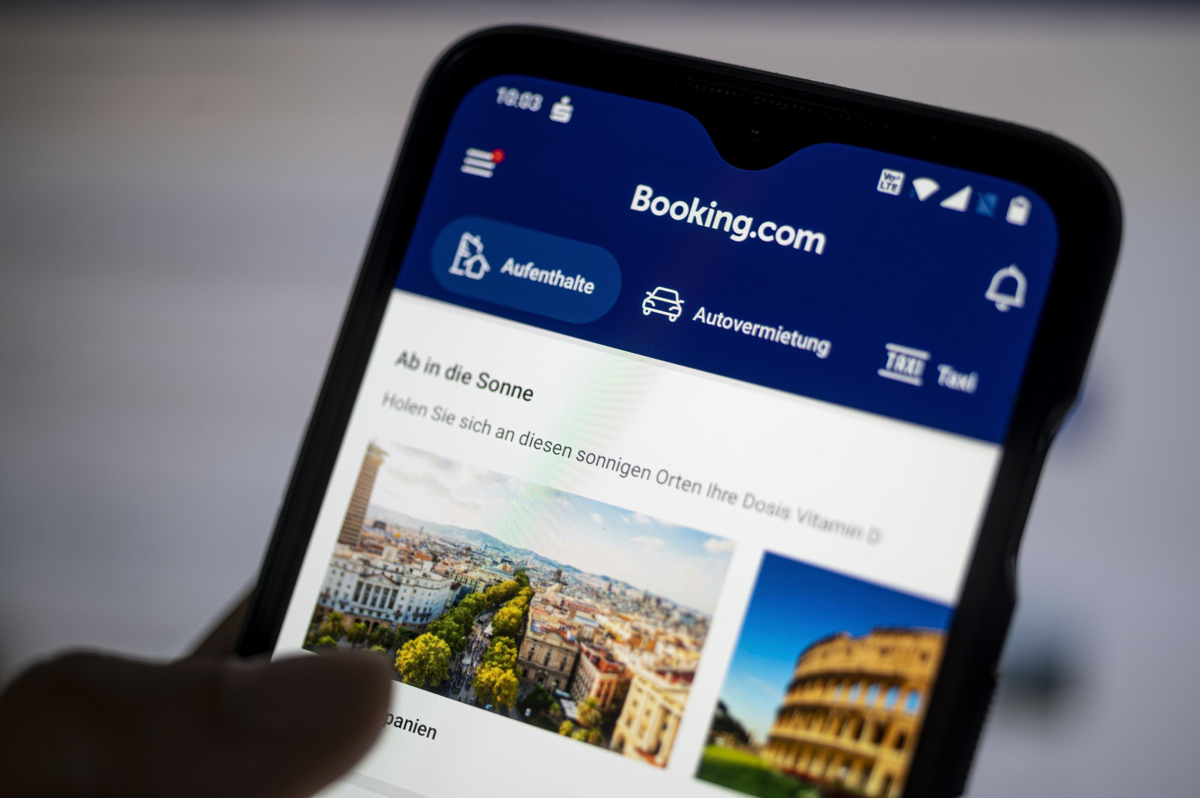 Auf einem Smartphone ist die App des Reiseportals Booking.com zu sehen.