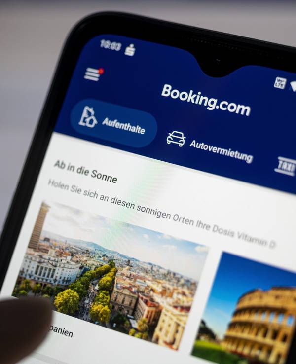 Auf einem Smartphone ist die App des Reiseportals Booking.com zu sehen.