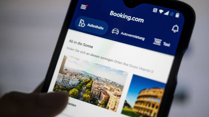 Auf einem Smartphone ist die App des Reiseportals Booking.com zu sehen.