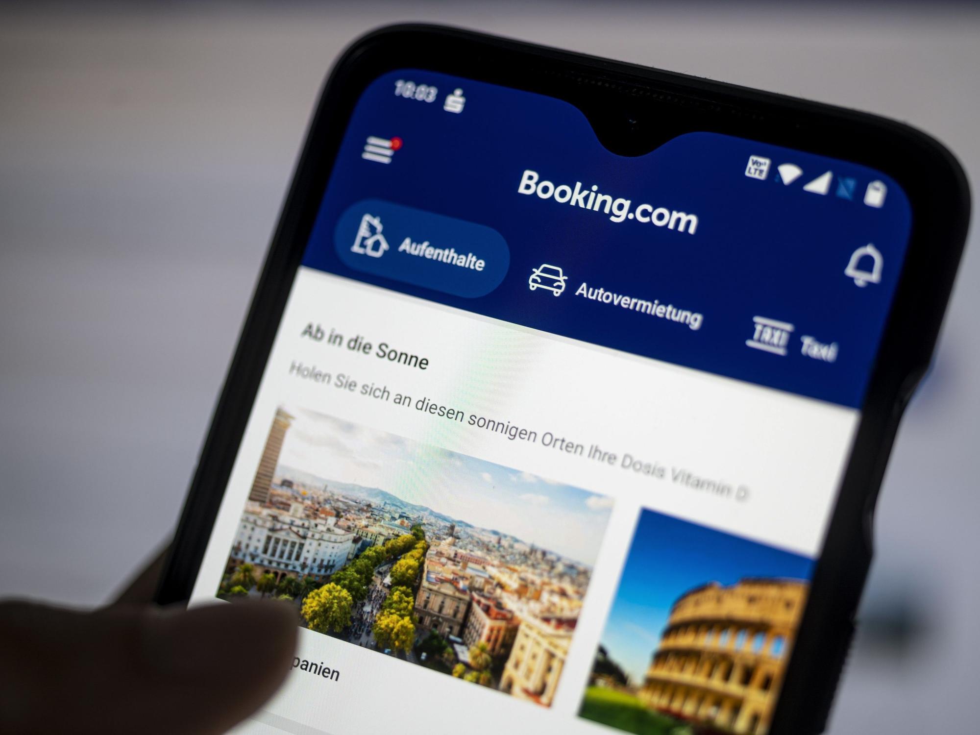 Auf einem Smartphone ist die App des Reiseportals Booking.com zu sehen.