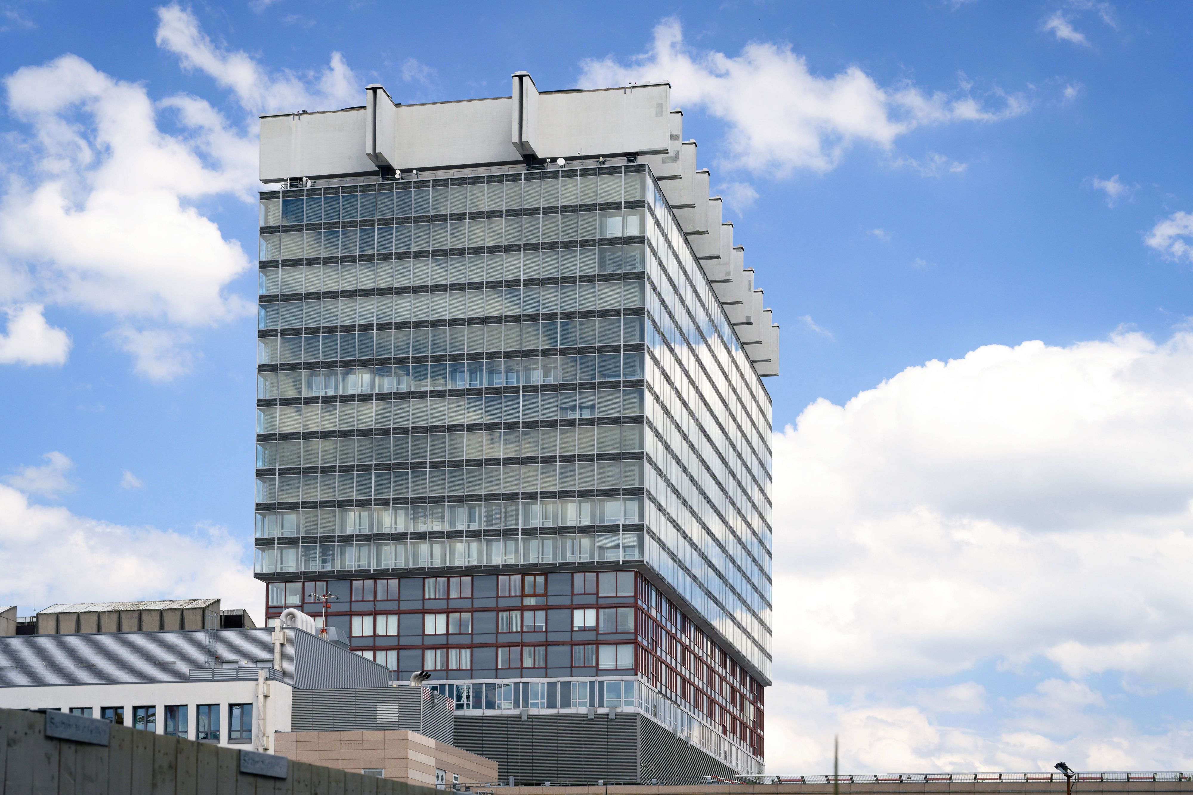 Das Bettenhaus der Uniklinik Köln vor blauem Himmel mit Wolken.